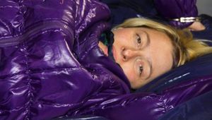 Sonja tied and gagged on bed with cuffs wearing a sexy lightblue rain pants and a purple down jacket (Pics)