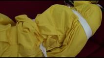 Mara tied and gagged with tape on a sofa wearing a sexy shiny yellow rainwear combination (Video)
