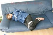 Katharina tied, gagged and hooded (breath control) on a sofa wearing sexy shiny nylon rainwear (Pics)