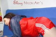 Jill posing and playing with you and herself wearing a sexy red shiny nylon shorts and an oldschool red/blue rain jacket (Pics)