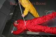 Watching Stella being tied and gagged with ropes and a ballgag on a operating table from Leonie both wearing sexy shiny nylon rainwear (Pics)