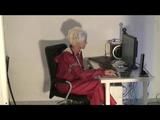 Blonde-haired archive girl being at home wearing shiny nylon rainwear (Video)