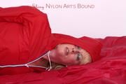 Pia tied and gagged on bed in a shiny bluerainpants and red rainjackert (Pics)