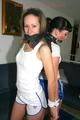 Jill and Petra tied and gagged to eachother in a living room both wearing sexy shiny nylon shorts and a top (Pics)