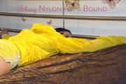 Lucy tied and gagged on bedposts face-down position wearing a sexy yellow shiny nylon shorts and a yellow rain jacket (Pics)