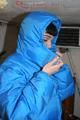 Jill posing in a cooling room wearing a shiny nylon rainpants and a down jacket (Pics)
