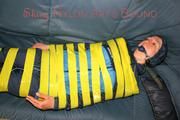 Katharina tied and gagged with tape on a sofa wearing shiny rainwear (Pics)