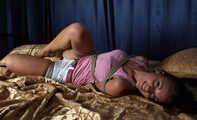 Hogtied barefoot Sharon in pink tank top and white shorts rolls and wiggles on the bed