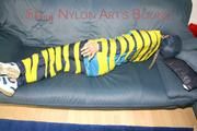 Katharina tied and gagged with tape on a sofa wearing shiny rainwear (Pics)