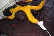 Stella tied and gagged in a shiny yellow rainsuit