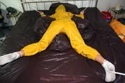 Stella tied and gagged in a shiny yellow rainsuit