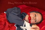 Lucy tied, gagged and hooded with ropes on a sofa wearing a sexy blue/red rainwear combination (Pics)