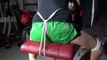 Watching sexy Sandra wearing a sexy green shiny nylon shorts and a black top being tied and gagged with ropes and a clothgag on a chair (Video)