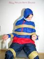 Katharina tied by using tape, gagged and hooded on a chair wearing sexy red/blue rainwear (Pics)