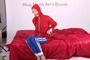 Pia tied and gagged on bed in a shiny bluerainpants and red rainjackert (Pics)