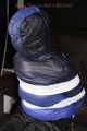 Sexy Mara wearing a black rain pants and a blue/black down jacket being tied, gagged and hooded with tape and clothgag (Pics)