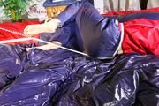 Sonja tied, gagged and hooded on bed with cuffs, chains and a gag wearing a sexy blue shiny nylon rain pants and a red rain jacket (Pics)