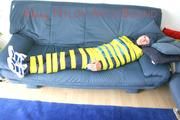 Katharina tied and gagged with tape on a sofa wearing shiny rainwear (Pics)