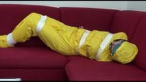 Mara tied and gagged with tape on a sofa wearing a sexy shiny yellow rainwear combination (Video)
