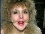 28 YR OLD BEAUTIFUL DOE EYED REBECCA IS MOUTH STUFFED, CLEAR WHITE TAPE GAGGED, RUBBER BAND BALL-GAGGED, HANDCUFFED & BOUND WITH TAPE (D46-9)
