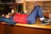 An archive girl tied and gagged on a bar wearing shiny nylon rainwear (Pics)