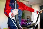 Pia tied and gagged on a crosstrainer for doing her workout right wearing a sexy blue shiny nylon shorts and an oldschool rain jacket (Pics)