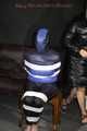 Sexy Mara wearing a black rain pants and a blue/black down jacket being tied, gagged and hooded with tape and clothgag (Pics)