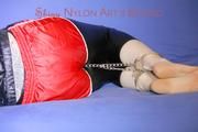 Mara ties and gagges herself with hand cuffs on a sofa wearing a supersexy black Leggings and a shiny nylon shorts and a rain jacket (Pics)