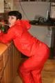 Jill posing in a bar wearing a sexy red rainwear combination with nothing under it (Pics)