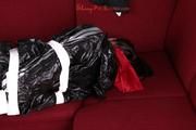 Alina tied and gagged in a shiny black PVC sauna suit