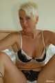 Short haired blonde MILF Claudia posing on bed