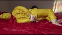 Jill tied, gagged and hooded on a bed wearing wonderful shiny yellow rainwear (Video)