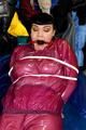 Jill tied and gagged in a semi-transparent purple PVC suit