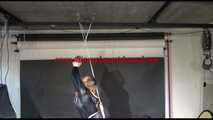 Sandra tied and gagged overhead with ropes wearing high heels, a sexy brown shiny nylon pant and a black rain jacket (Video)