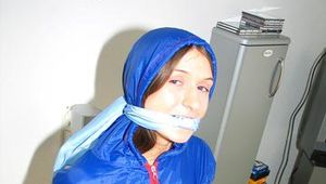 Katharina tied by using tape, gagged and hooded on a chair wearing sexy red/blue rainwear (Pics)