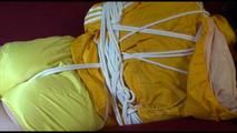 Lucy tied and gagged on a red sofa wearing a supersexy yellow shiny nylon shorts and a yelow rain jacket (Video)