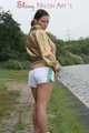 Watching out beautiful archive girl wearing a white shiny nylon shorts and a golden rain jacket posing outdoor (Pics)