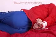 Pia tied and gagged on bed in a shiny bluerainpants and red rainjackert (Pics)