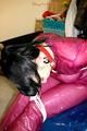 Jill tied and gagged in a semi-transparent purple PVC suit