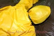 Stella tied and gagged on a bed wearing a supersexy yellow rainwear combination (Pics)