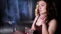 Dark-haired Russian girl smoking a cigarette on the studio couch