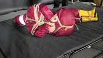 Alice bound and gagged in a nylon Rainsuit