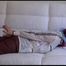 Mara tied and gagged on a white sofa in a reading lounge wearing a sexy brown rain pants and a white rain jacket (Video)