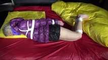 Watching sexy Sonnja wearing a black shiny nylon down skirt and a purple downjacket being tied and gagged with ropes and a ballgag on a bed (Video)
