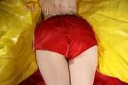 Sexy Sonja posing for you in a red shiny nylon shorts and a tshirts and then she takes it off and plays with the bedding (Pics)