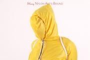 Jill tied and gagged in a shiny yellow rainsuit and rubber boots