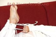 Pia tied and gagged on a sofa wearing a shiny white rain combination (Pics)