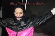 Sexy Mara tied, gagged and hooded overhead on hands and feet with ropes and a cloth gag wearing a sexy black/pink rainwear combination (Pics)