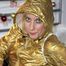 Pia posing in bed wearing golden shiny nylon rainwear and wings (Pics)