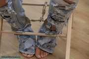 Hot jeans girl cuffed on a chair